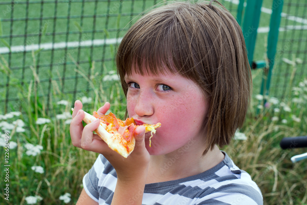 little girl with pleasure eats a pizza in the park little girl with pleasure eats a pizza in the park