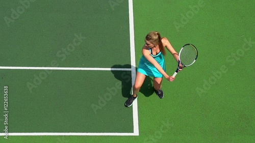 Young female tennis player backhand return.