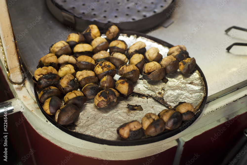 Fototapeta premium The iron plate full of chestnuts in the shell