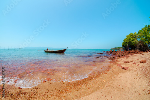 small fishing boat in the sea at red rock island, satun province © designbydx
