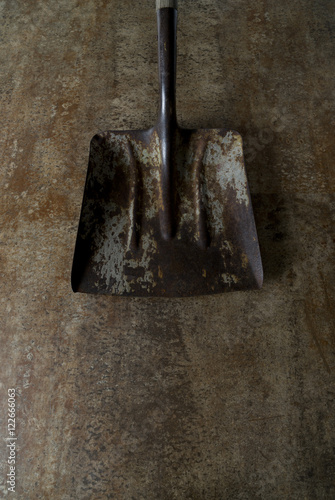 Rusty shovel head on metal floor