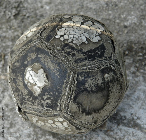 Worn football on concrete ground