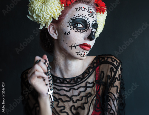 photo portrait of girl to dress up in the image of the goddess of death with the rosary in his hands praying Los Muertos