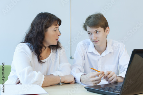 Mature teacher and student in the classroom at the table