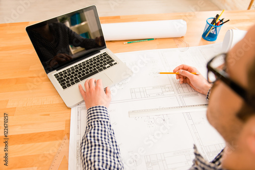 Close up photo of working place with laptop of young architect