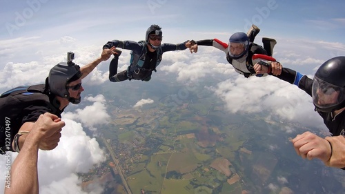 A group of friends holding hands teamwork skydiving
