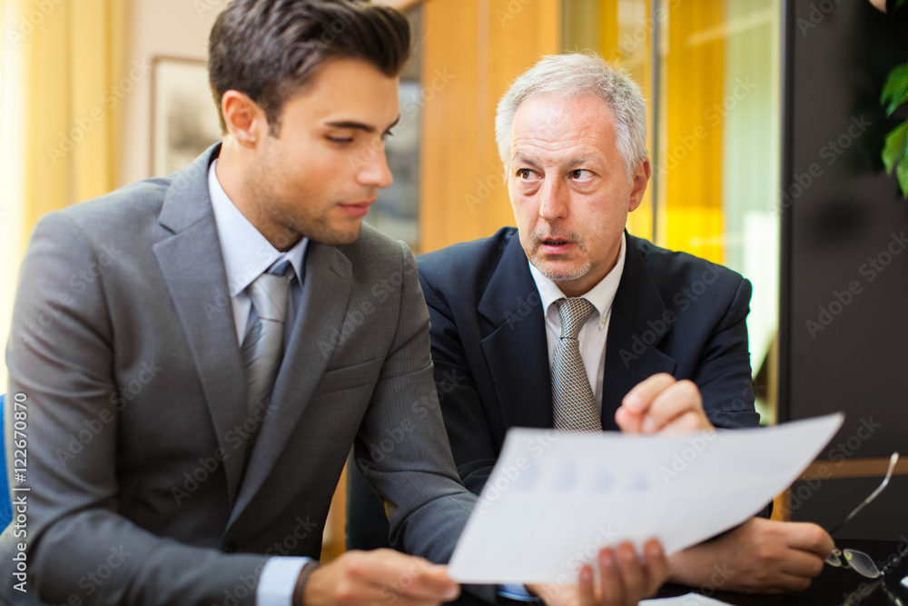Businessman showing a document to his colleague Businessman showing a document to his colleague