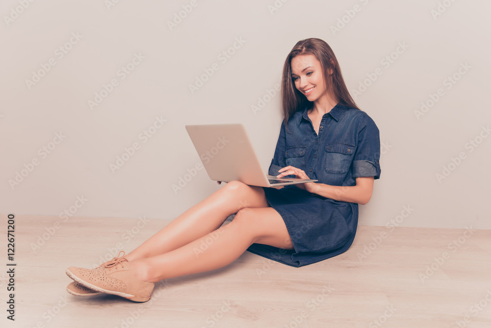 Smiling woman sitting on floor with laptop and doing her job onl Smiling woman sitting on floor with laptop and doing her job onl