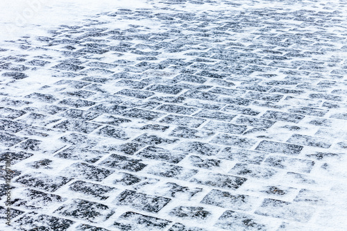 Sidewalk Cobblestone pavement covered with snow and ice