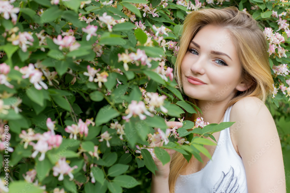 beautiful lovely girl with long blonde hair enjoying nature near blooming rosebush in a white t-shirt with full lips bright summer day beautiful lovely girl with long blonde hair enjoying nature near blooming rosebush in a white t-shirt with full lips bright summer day