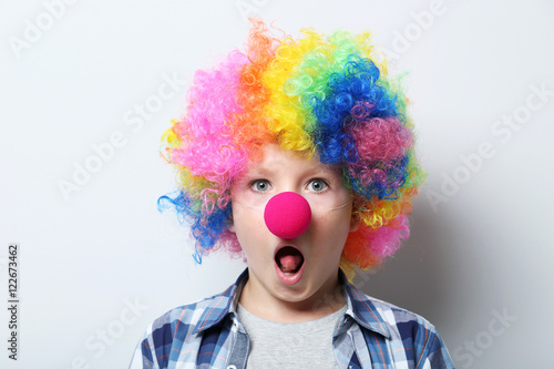 Portrait of little boy clown on grey background