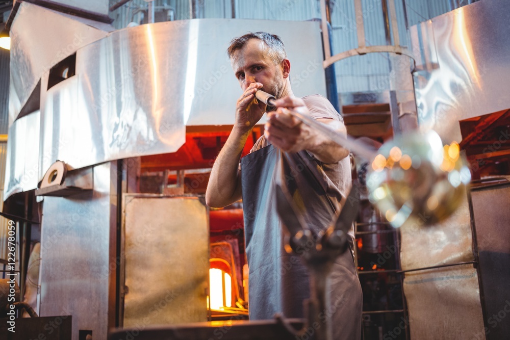 Glassblower working in factory Glassblower working in factory