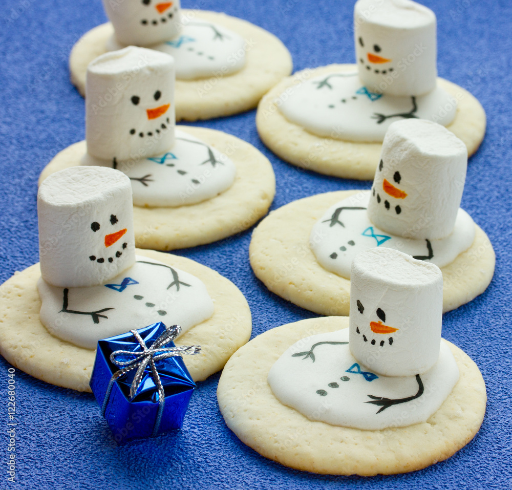 Snowmen of cookies and marshmallow on a blue background