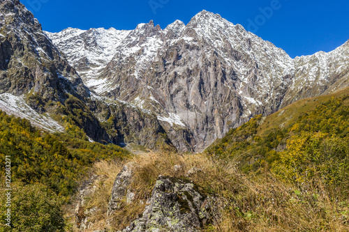 Landscape mountains with yellow leaves and white snow in autumn