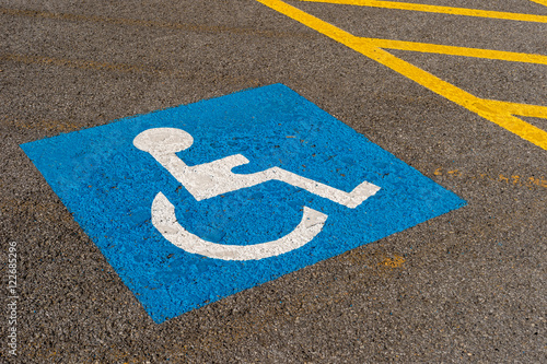 Disabled blue parking sign painted on dark asphalt in Canada