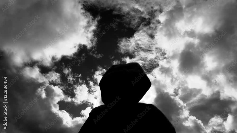 Dark and mysterious silhouetted figure raises hands and attacks camera. Dark and mysterious silhouetted figure raises hands and attacks camera.