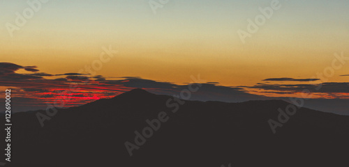 Sunset behind mountain silhouette photo