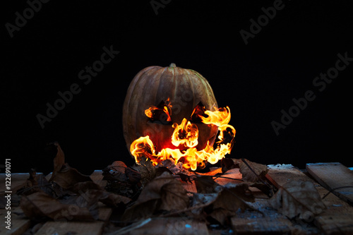 Halloween pumpkin spewing flames of fire on a black background