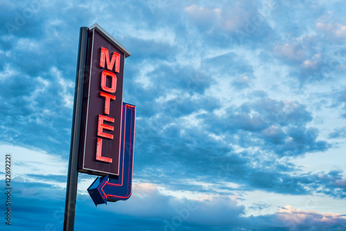 Red motel neon sign over a sunset cloudy sky