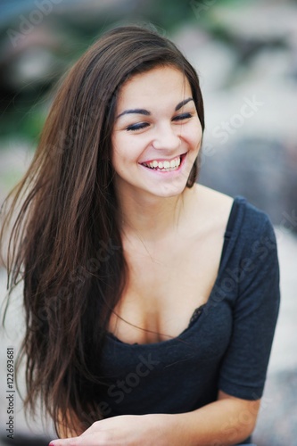 Happy long hair woman laughing with eyes closed, close-up.