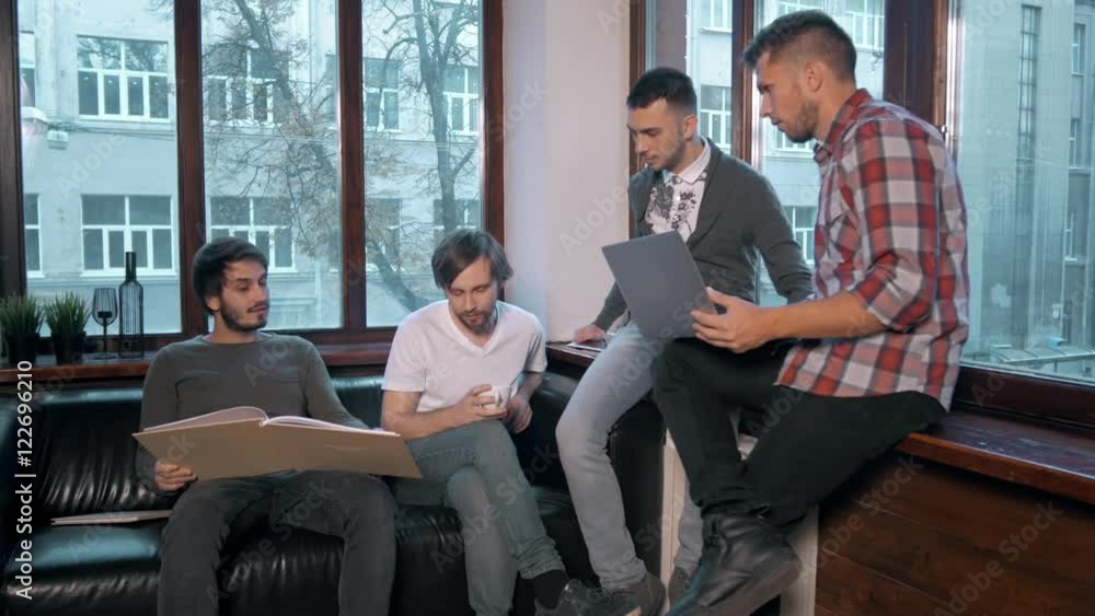 Group of entrepreneurs working and taking notes together in a little office. Freelancer meeting, man with laptop drink coffee in coworking. Group of entrepreneurs working and taking notes together in a little office. Freelancer meeting, man with laptop drink coffee in coworking.