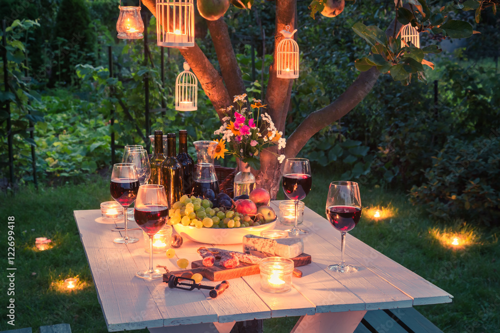 Obraz premium Piękny stół pełen sera i mięs w ogrodzie o zmierzchu