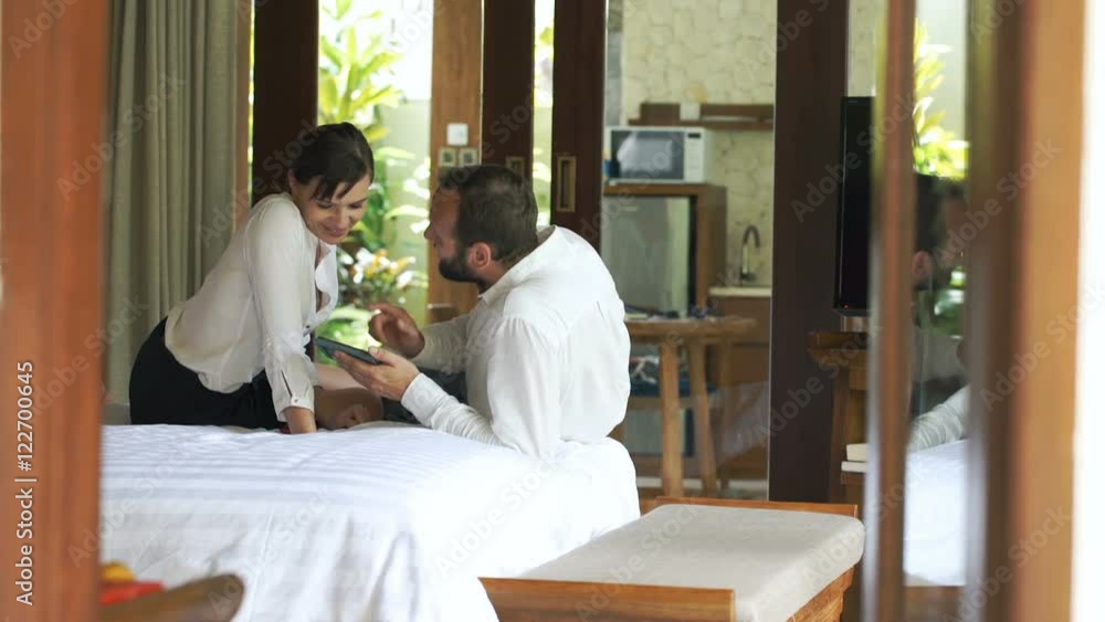 Young, happy couple talking and using smartphone on bed in bedroom at home
Young, happy couple talking and using smartphone on bed in bedroom at home