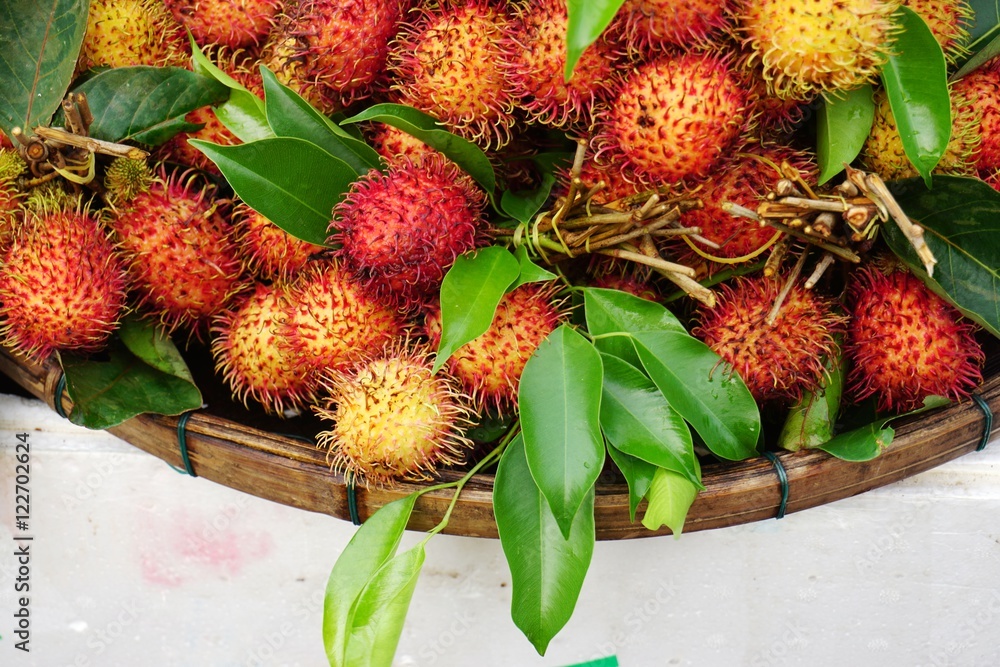 Fototapeta premium Red rambutan fruit for sale at a market in Vietnam