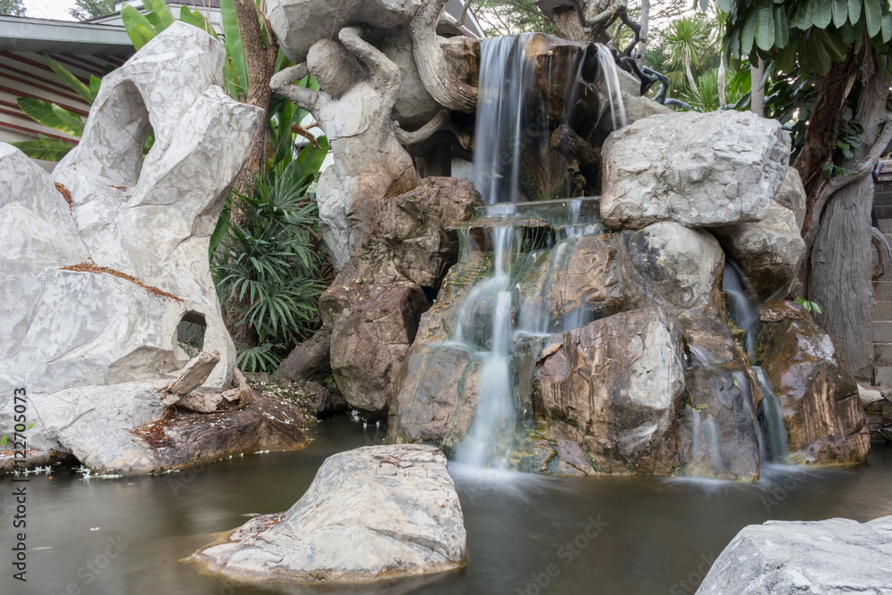 Waterfall motion on a stone in the garden. Beautiful nature Waterfall motion on a stone in the garden. Beautiful nature