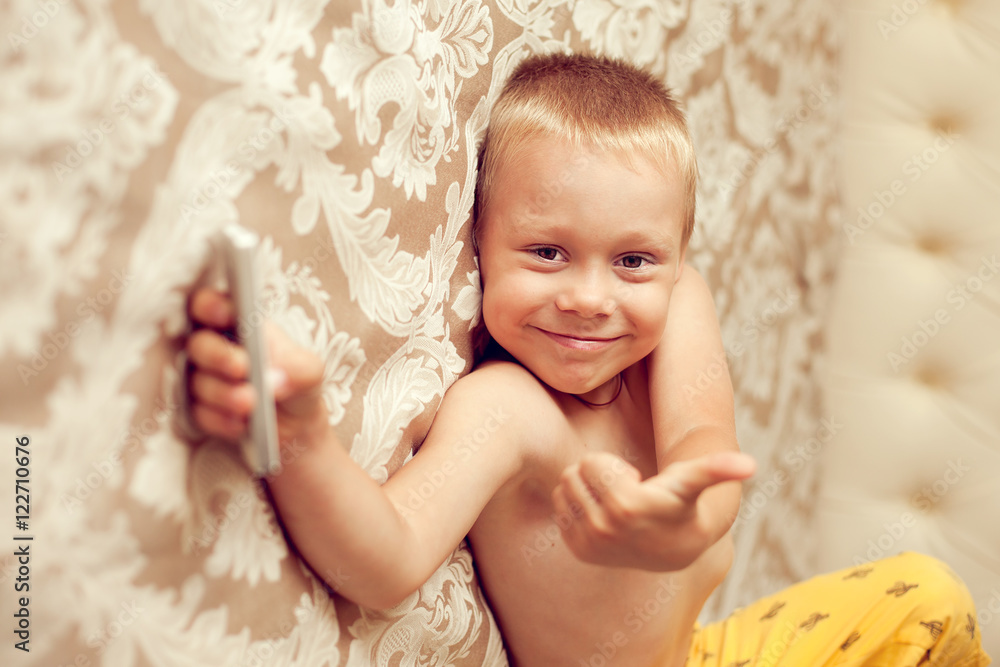 White European 5 years old boy lying on the bed in the bedroom w White European 5 years old boy lying on the bed in the bedroom w