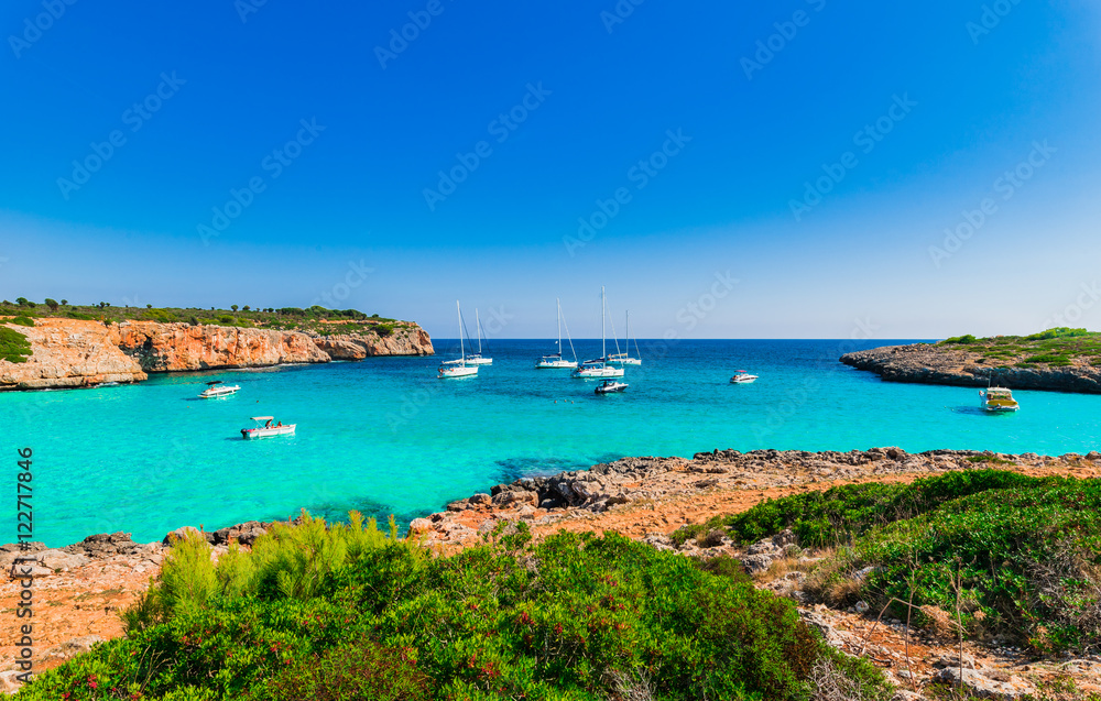 Idyllic view to the bay Cala Varques with turquoise water and boats at Majorca Spain