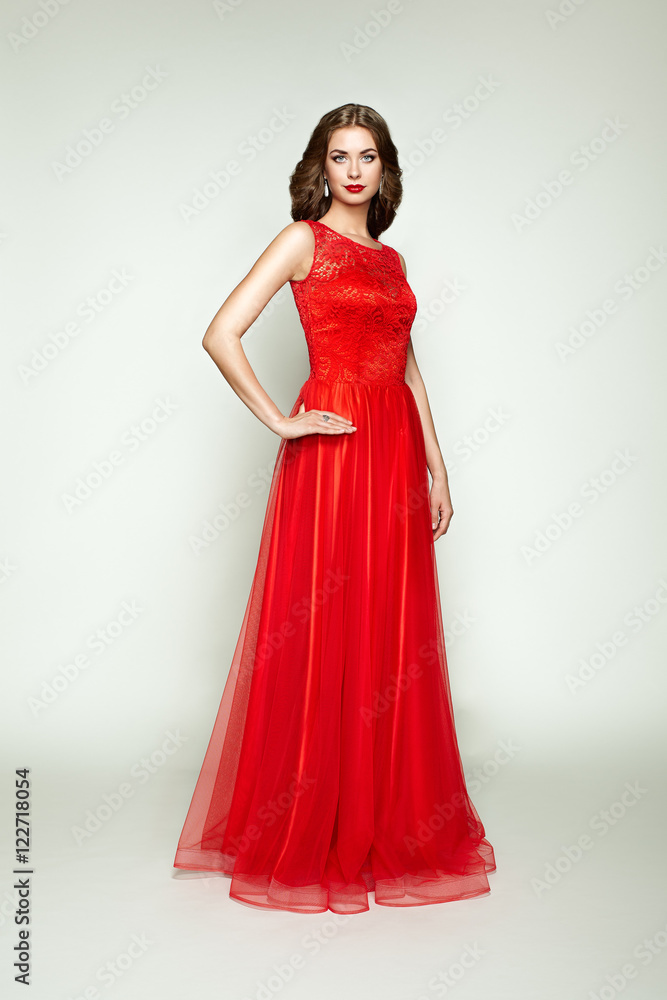 Fashion portrait of beautiful woman in elegant red dress. Girl with elegant hairstyle and jewelry