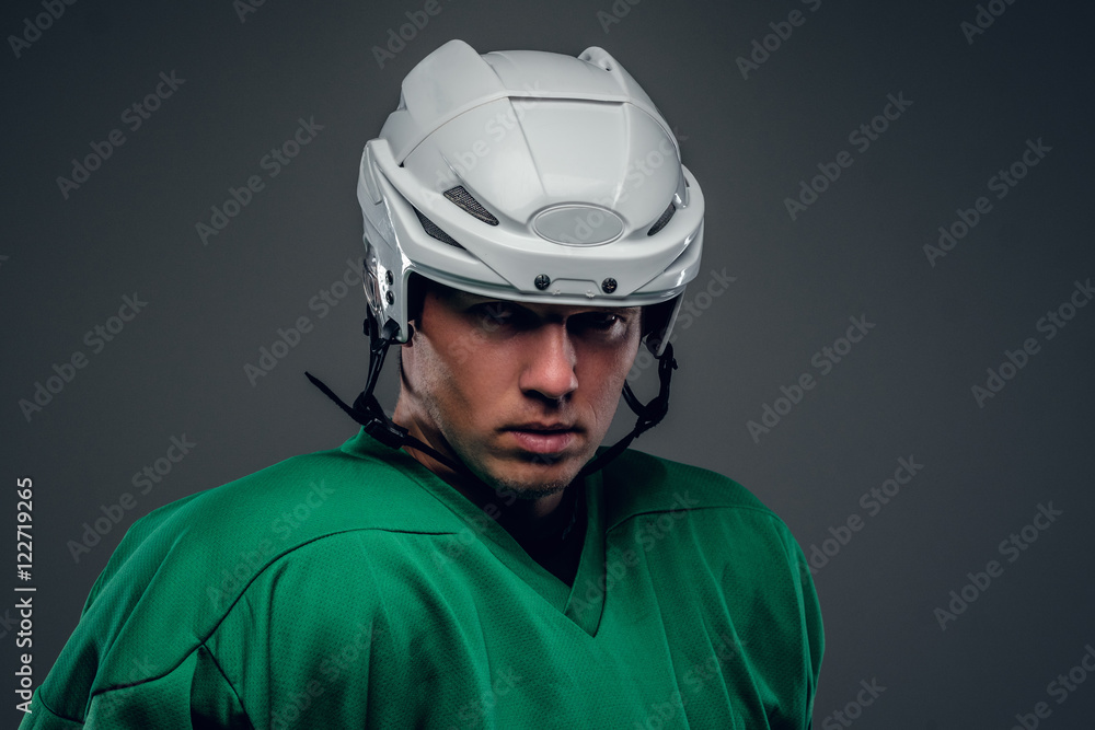 Naklejka premium Portrait of hockey player on grey background.