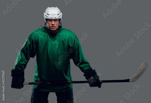 Hockey player holds gaming stick.