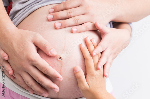 Pregnant woman and her family holding her hands and touching her