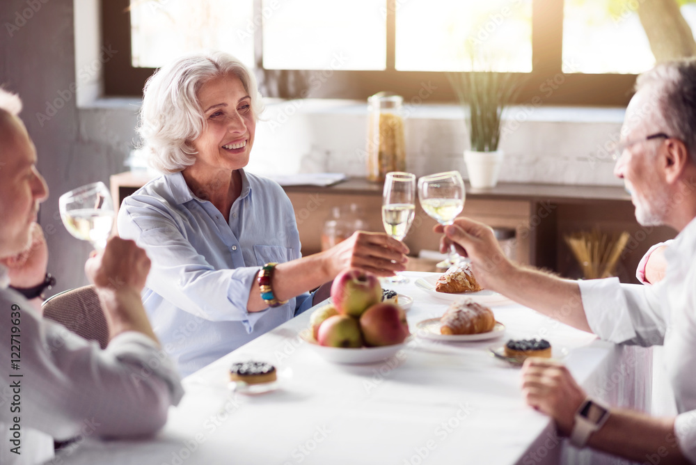 Elderly ceerful woman drinking with her family