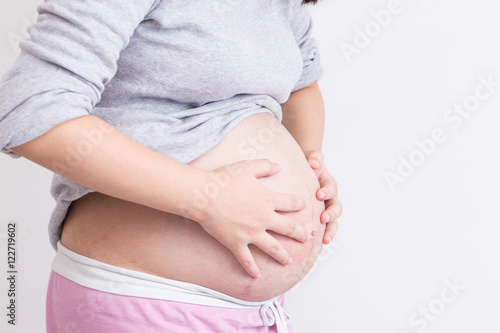 Pregnant woman has stomachache and touching her belly