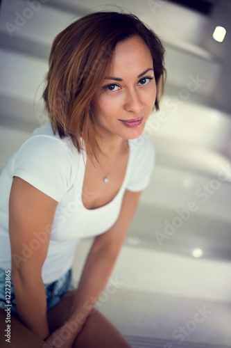Sexy young model girl sitting on stairs at home with modern design