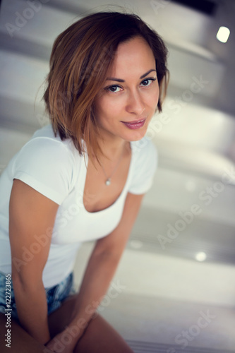 Free Download Sexy young model girl sitting on stairs at home with modern design - GFXLoad