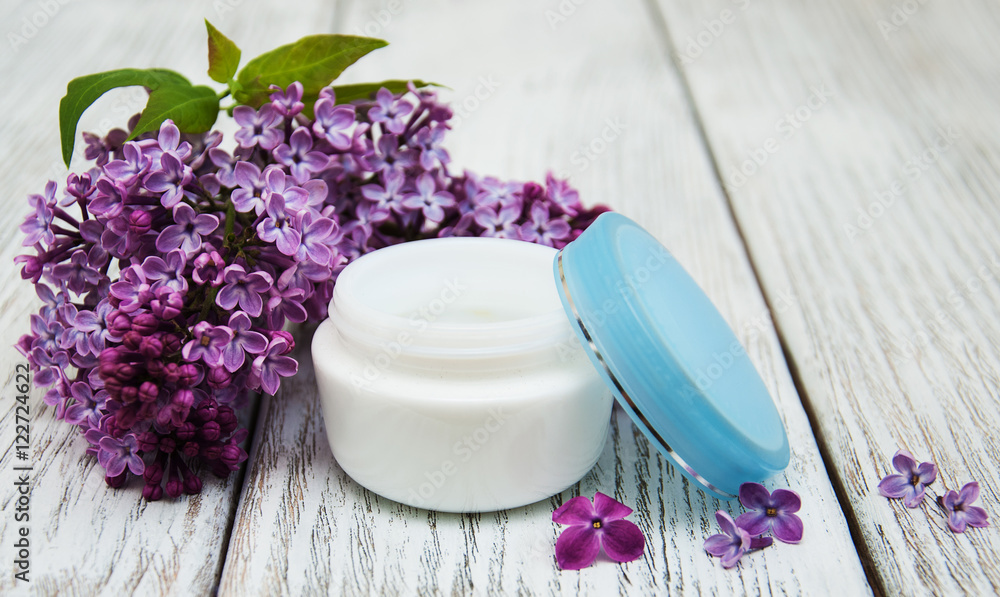 moisturizing cream and lilac flowers moisturizing cream and lilac flowers