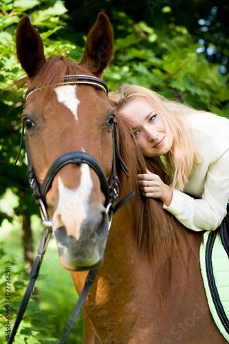 Fototapeta Naklejka Na Ścianę i Meble -  Девушка со светлыми волосами лежит на лошади