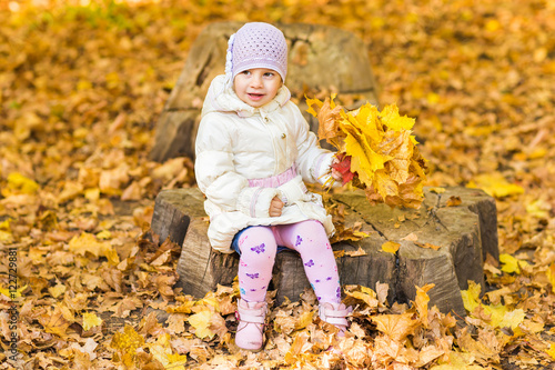 Little baby girl with autumn leaves