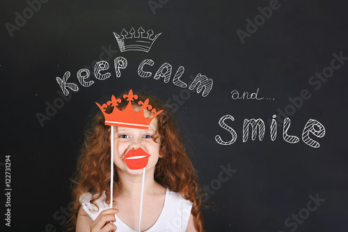 Funny girl with carnival crown and lips showing her teeth, stand
