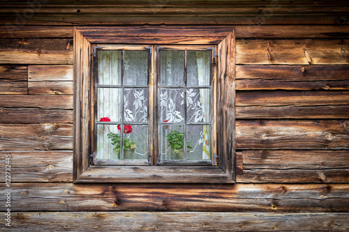Fototapeta The old window of old wooden house. Background of wooden walls