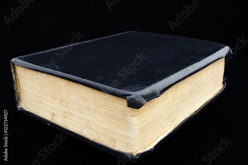 Big closed book isolated on a black background