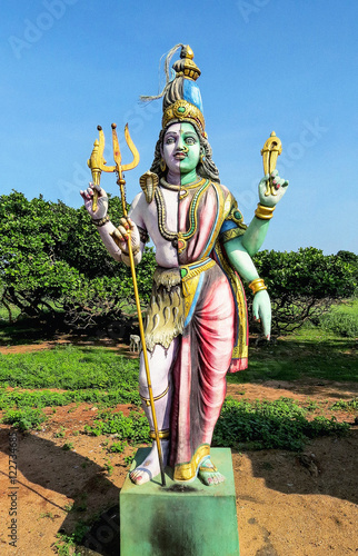 Sample of ancient Indian sculpture of the XVII century - a statue of the god Shiva Ardhanarishvara near the old temple Parameswara of the XVI century, not far from Pondicherry. South India.