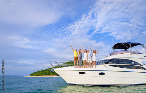 Friendship and vacation. Happy young people standing on the yacht deck and enjoying the view  sailing the sea.