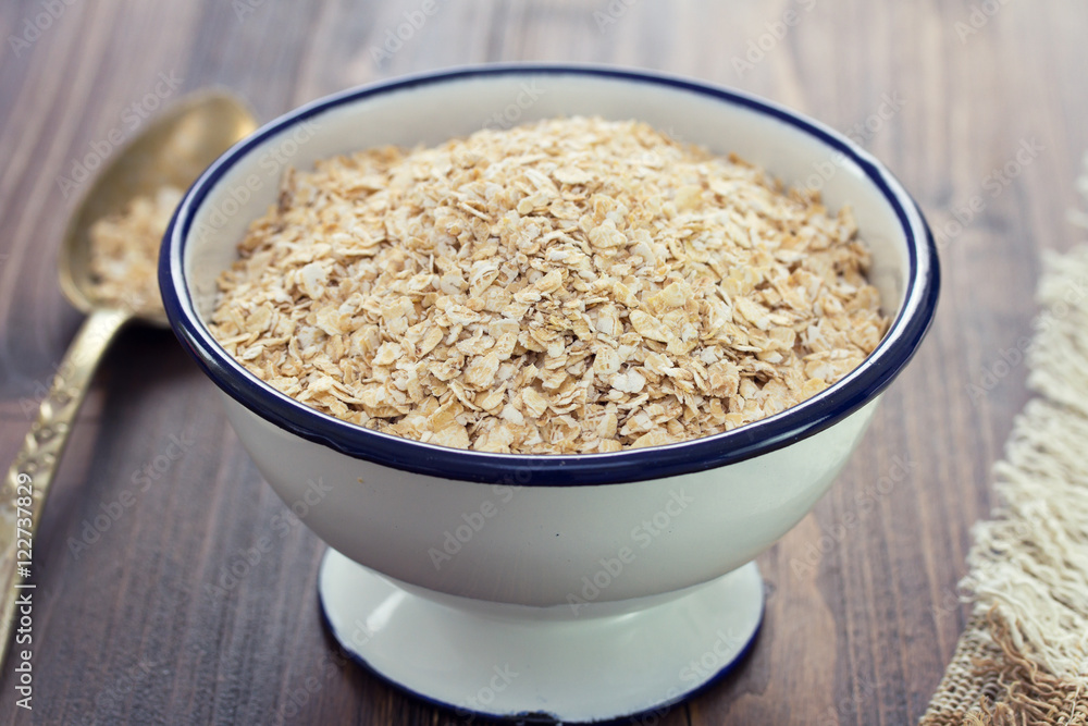 oat on white bowl on wooden background oat on white bowl on wooden background