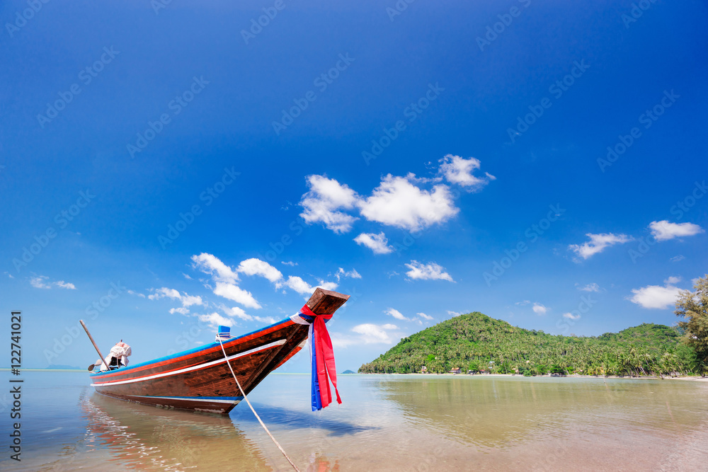 Longtail boat in the clear sea over blue sky