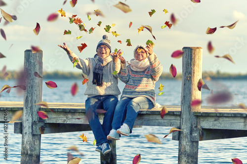 Herbst, Senioren werfen buntes Laub in die Luft photo